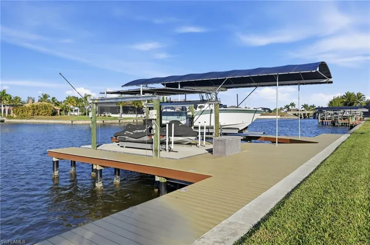 Dock area featuring boat lift and a water view