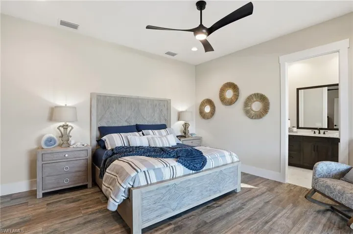 Bedroom featuring dark wood-style flooring, ceiling fan, recessed lighting, and ensuite bath