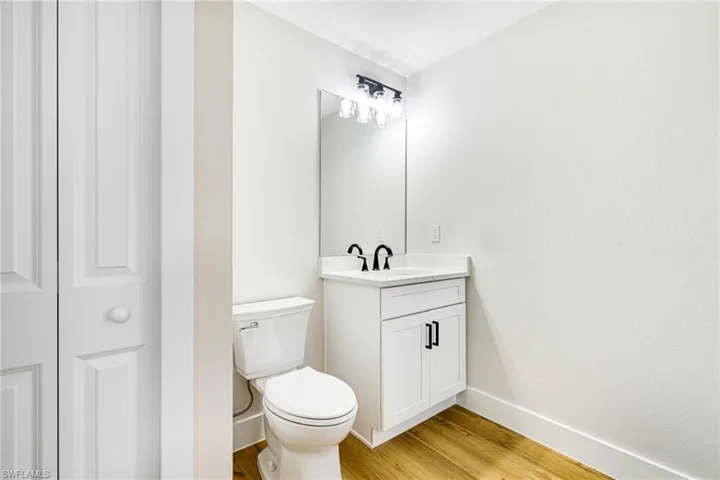 Bathroom featuring vanity, light wood-style floors, and a closet