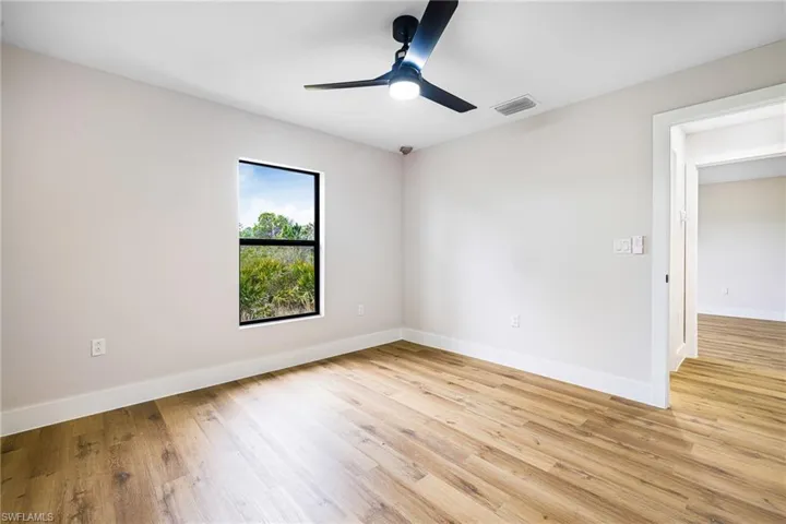 Empty room with light wood-style flooring and ceiling fan