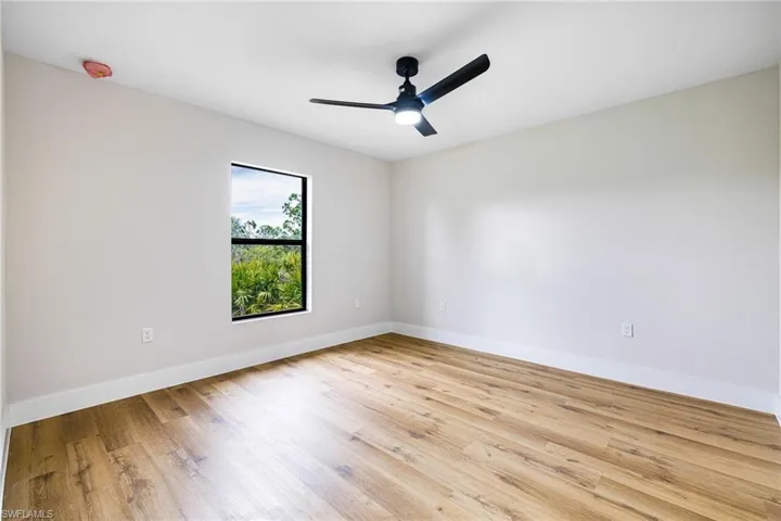 Empty room featuring light wood-style flooring and a ceiling fan