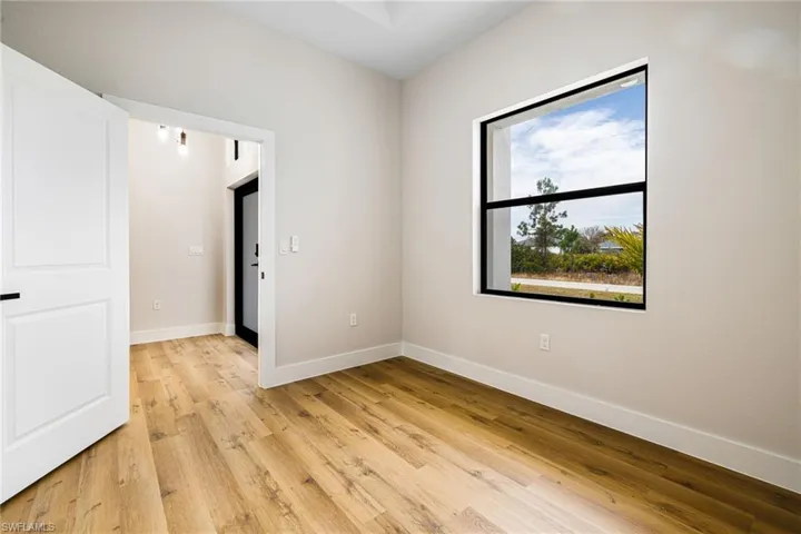 Unfurnished room with light wood finished floors and baseboards