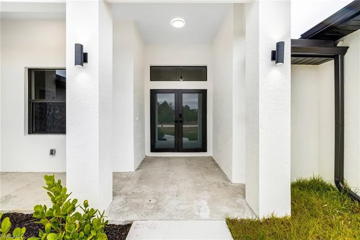 Property entrance featuring french doors and stucco siding