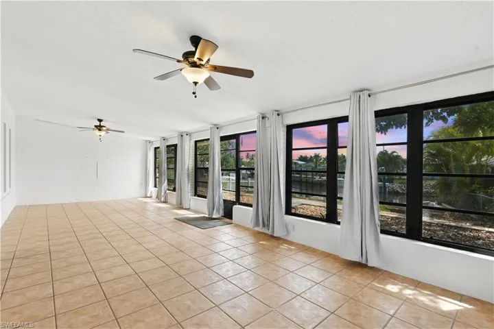 Unfurnished sunroom with tile patterned flooring and plenty of natural light