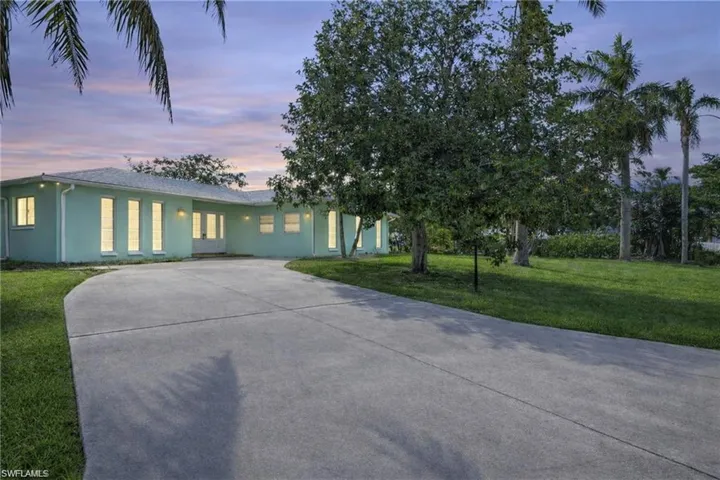 View of front of home featuring a yard, stucco siding, and concrete driveway