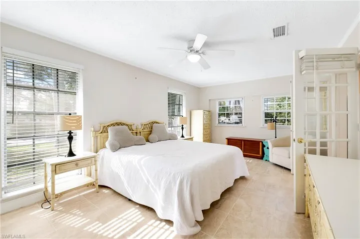 Tiled bedroom featuring ceiling fan