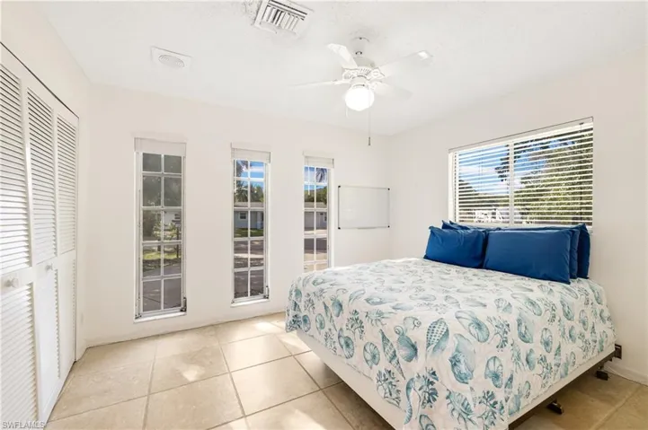 Tiled bedroom with a closet and ceiling fan