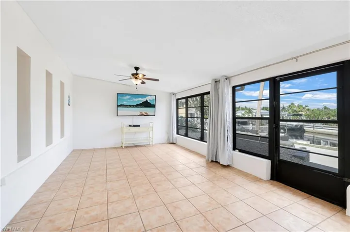 Unfurnished living room with light tile patterned flooring and ceiling fan