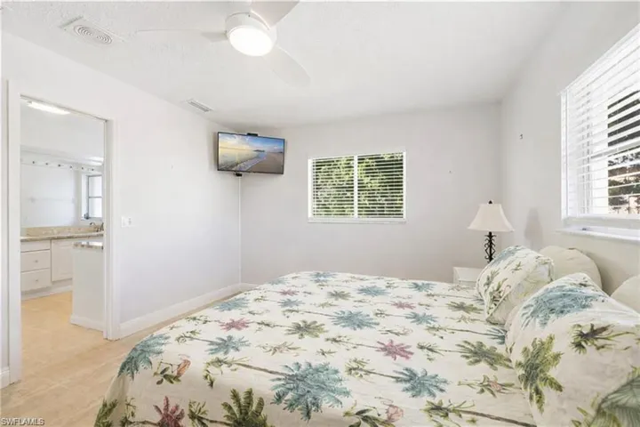 Bedroom featuring a textured ceiling, ceiling fan, and ensuite bath