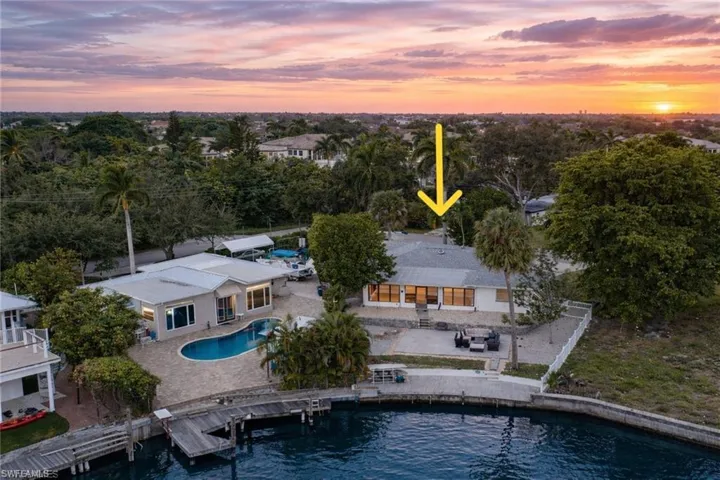 Aerial view at dusk of view of pool area and a water view