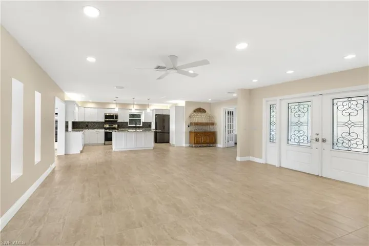 Unfurnished living room featuring french doors, ceiling fan, and light tile patterned floors