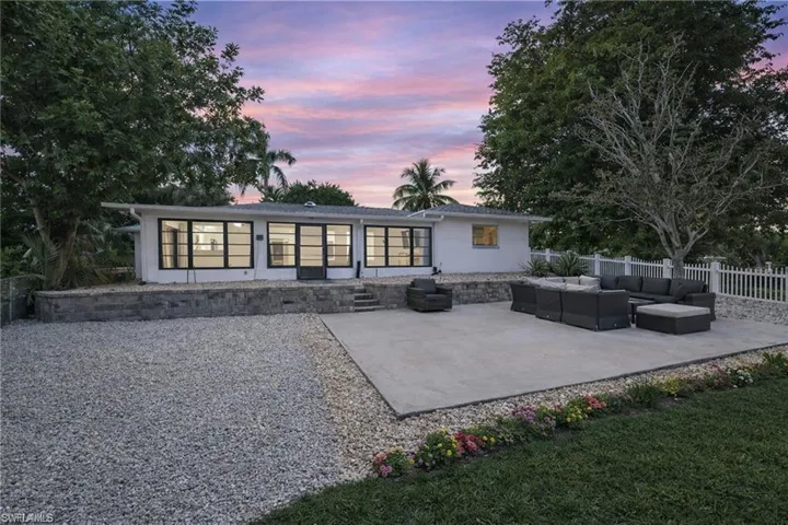 Back of property at dusk with an outdoor hangout area and a patio