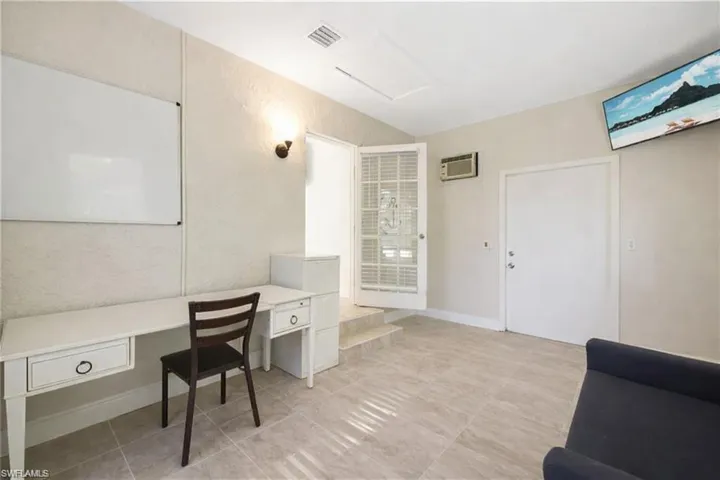 Office with a textured wall and a wall mounted air conditioner