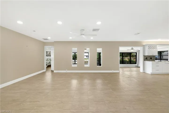 Unfurnished living room with light tile patterned flooring and ceiling fan
