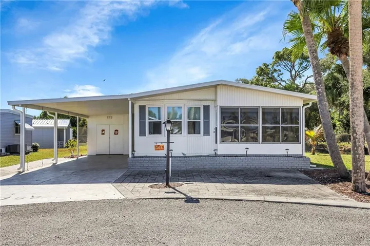 Manufactured / mobile home featuring a carport and driveway
