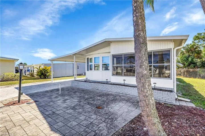 Back of house with an attached carport and a patio area