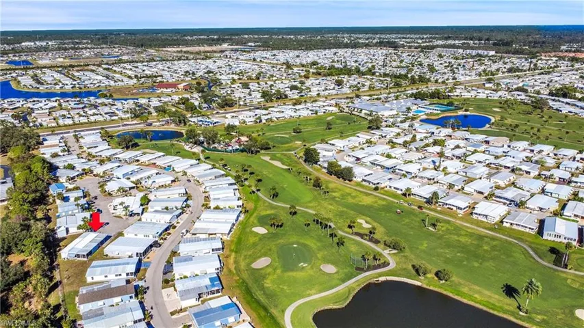 Aerial view of residential area featuring a nearby body of water and a local golf course