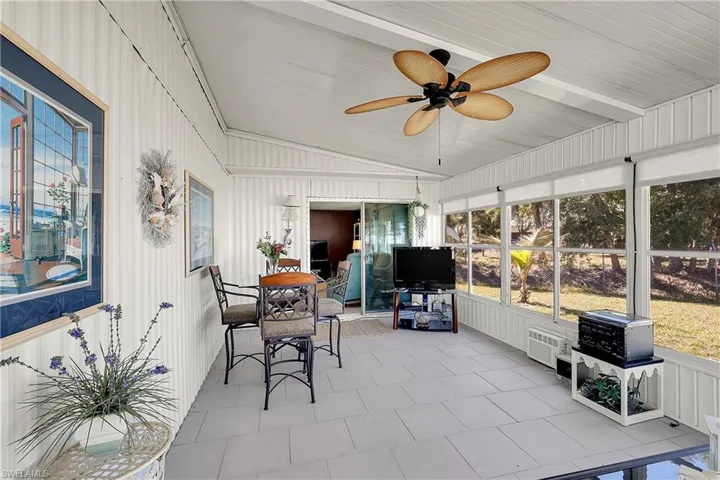 Sunroom / solarium featuring outdoor dining space, ceiling fan, and lofted ceiling