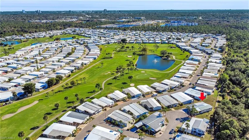 Aerial view of residential area featuring a nearby body of water and a local golf course