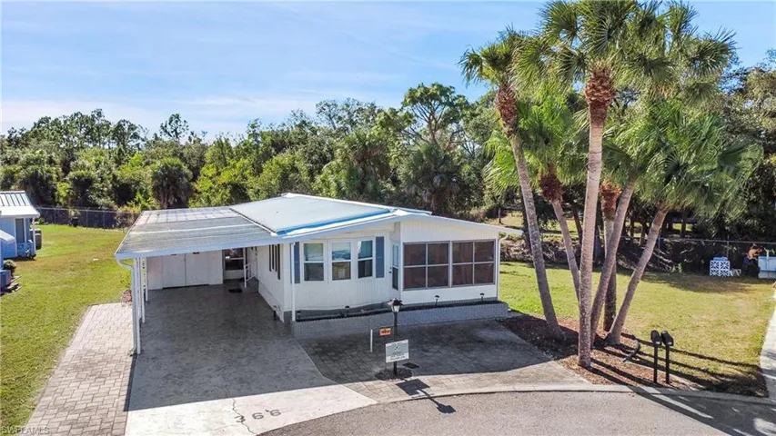 View of front of home featuring decorative driveway, a carport, and a patio area