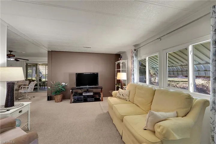 Carpeted living area with a ceiling fan