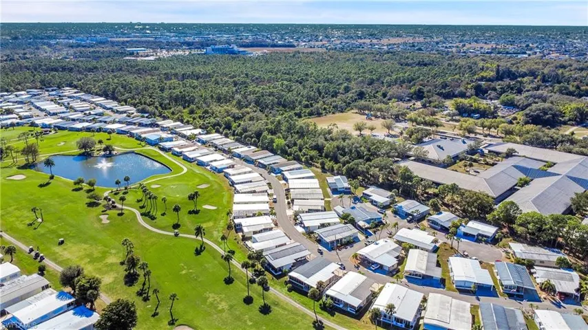 Aerial perspective of suburban area with a nearby body of water and a golf club