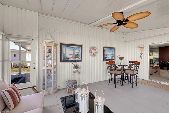 Living area featuring a ceiling fan and tile patterned floors