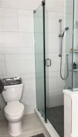 Full bath featuring a stall shower and toilet