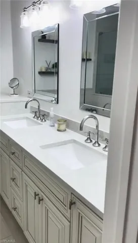 Bathroom featuring double vanity and light tile patterned flooring