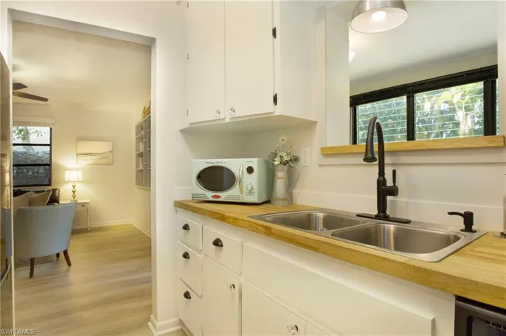 Kitchen featuring white cabinets, plenty of natural light, and light luxury vinyl wood-type flooring