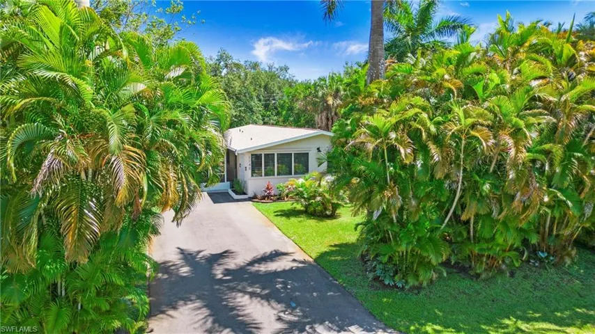 View of front of home with front yard and flora