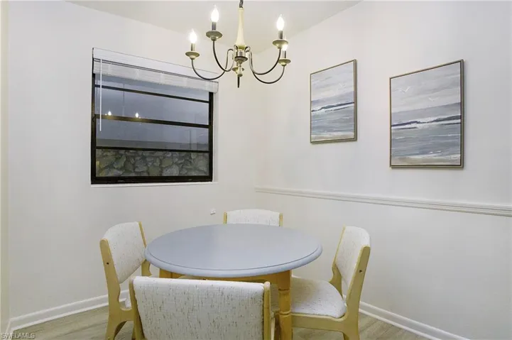 Dining room featuring luxury vinyl wood-type flooring and a chandelier