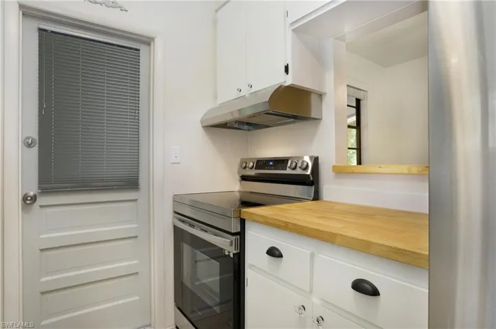 Kitchen featuring white cabinets and stainless steel electric range oven