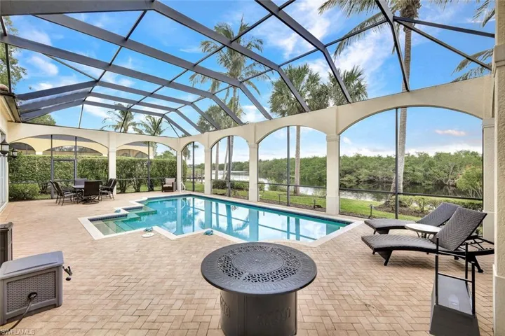 View of swimming pool featuring a water view, a lanai, and a patio