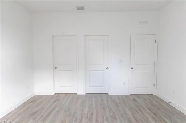 Master bedroom with light vinyl flooring.