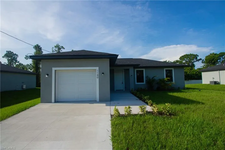 Ranch-style home with a front lawn, a garage, stucco siding, and driveway