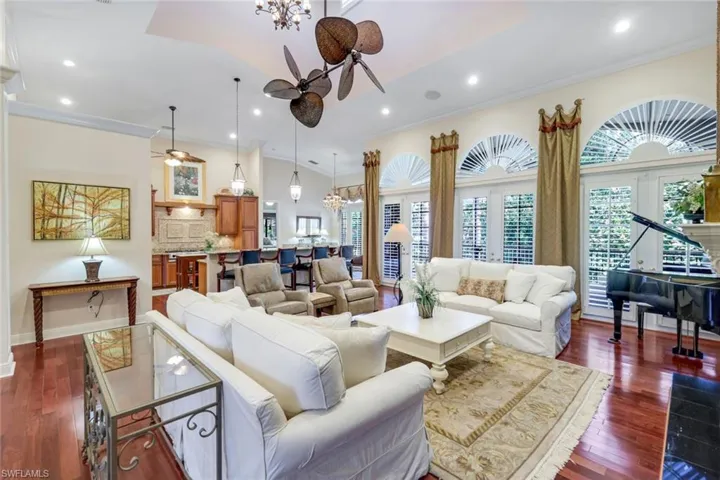 Kitchen featuring a chandelier, a tiled fireplace, dark wood finished floors, french doors, and crown molding