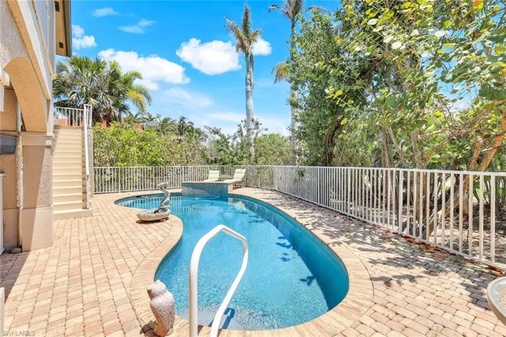 View of swimming pool featuring stairs, a patio area, a fenced backyard, a sunroom, and a ceiling fan