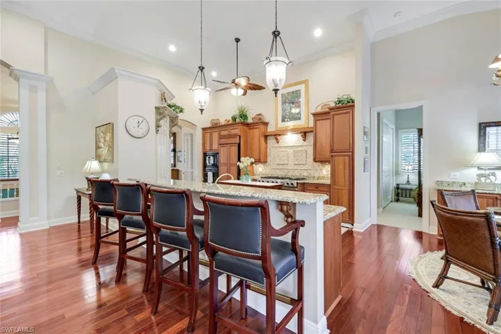 Dining area with a chandelier, dark wood-style flooring, plenty of natural light, baseboards, and crown molding