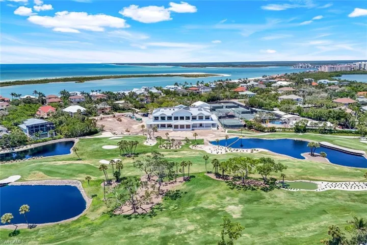 Aerial perspective of suburban area featuring a large body of water and a golf club