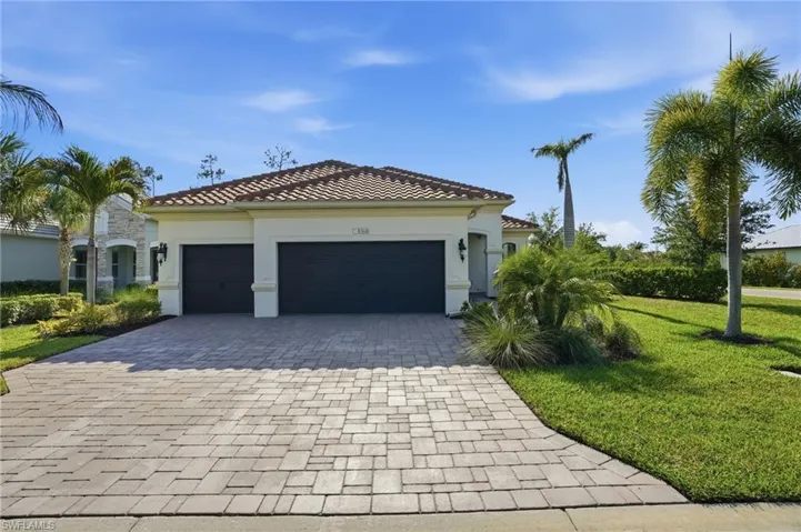 Mediterranean-style exterior featuring a tile roof, stucco finish, and dual garage doors