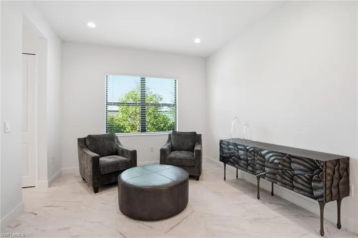 Light-filled interior space featuring white walls and large format tile flooring