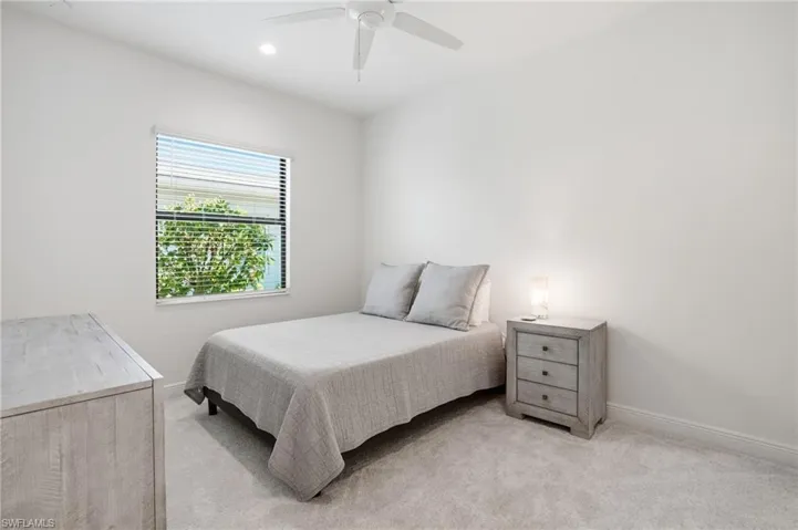 Carpeted room featuring a single window with horizontal blinds, recessed ceiling lighting, and a ceiling fan