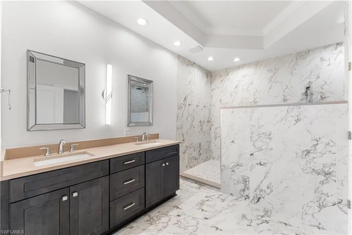 The master bath has an enormous walk in shower with 3 shower heads. Tray ceiling and recessed and custom  lighting.