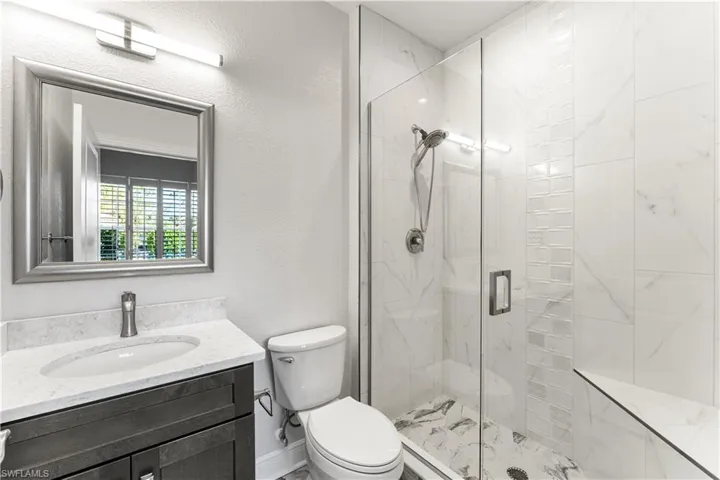 3rd bathroom is ensuite. Floor to ceiling tile with listello. Seamless glass shower enclosure.