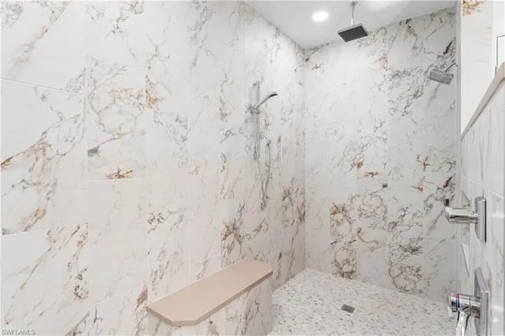 The walk in shower has a seating area as well. Rain shower head.Floor to ceiling tile.