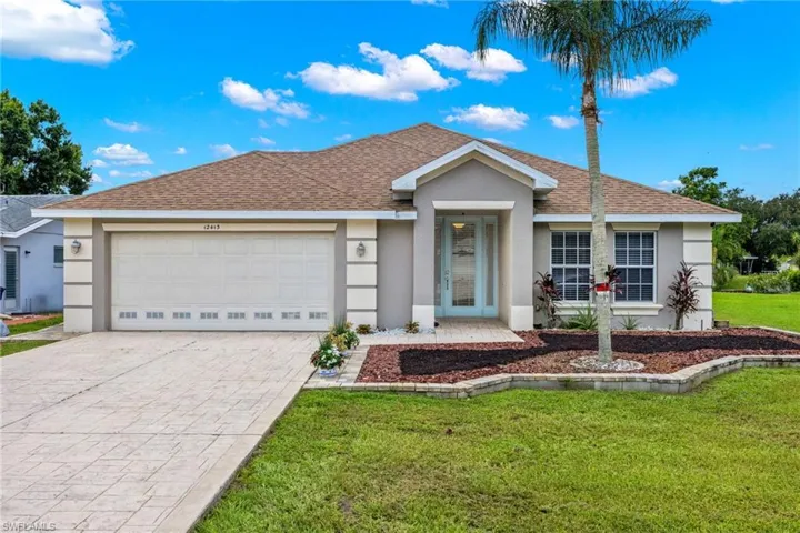 Ranch-style house with a garage and a front lawn