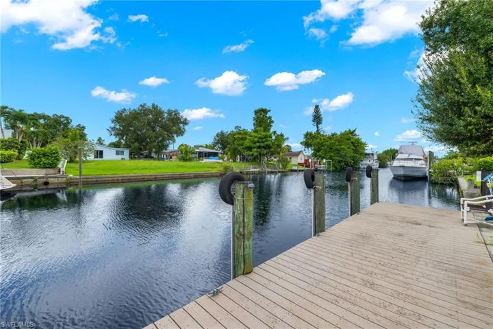 Dock area with a water view and a yard