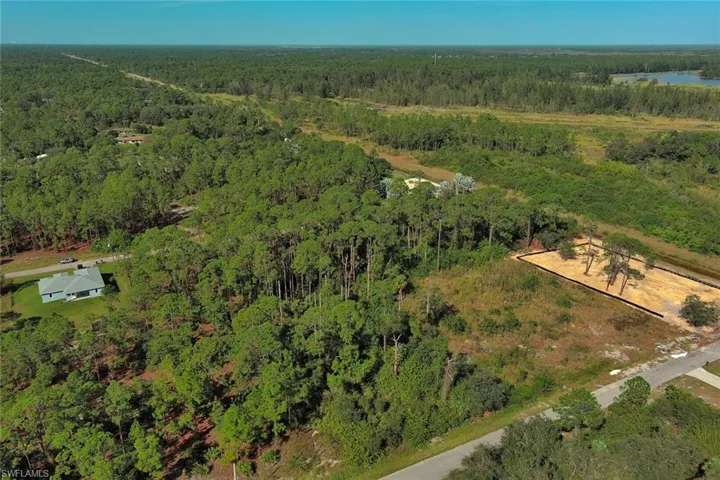 Aerial overview of property's location with a heavily wooded area