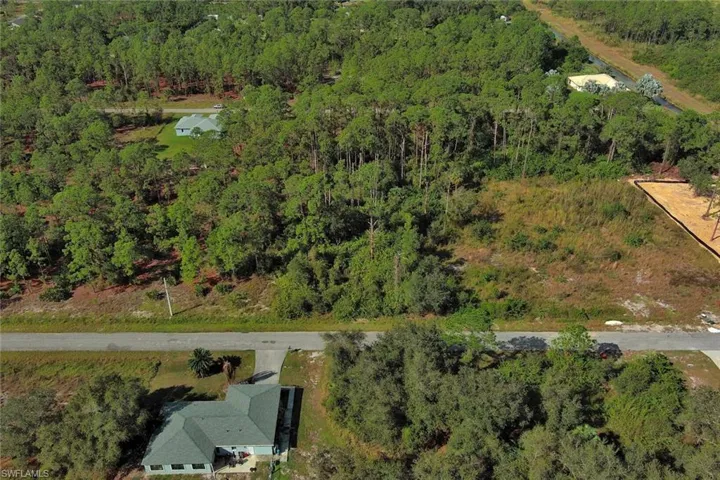 Aerial view of property's location featuring a forest